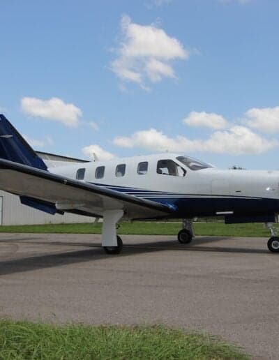 Side view of a white and blue aircraft on the ground.