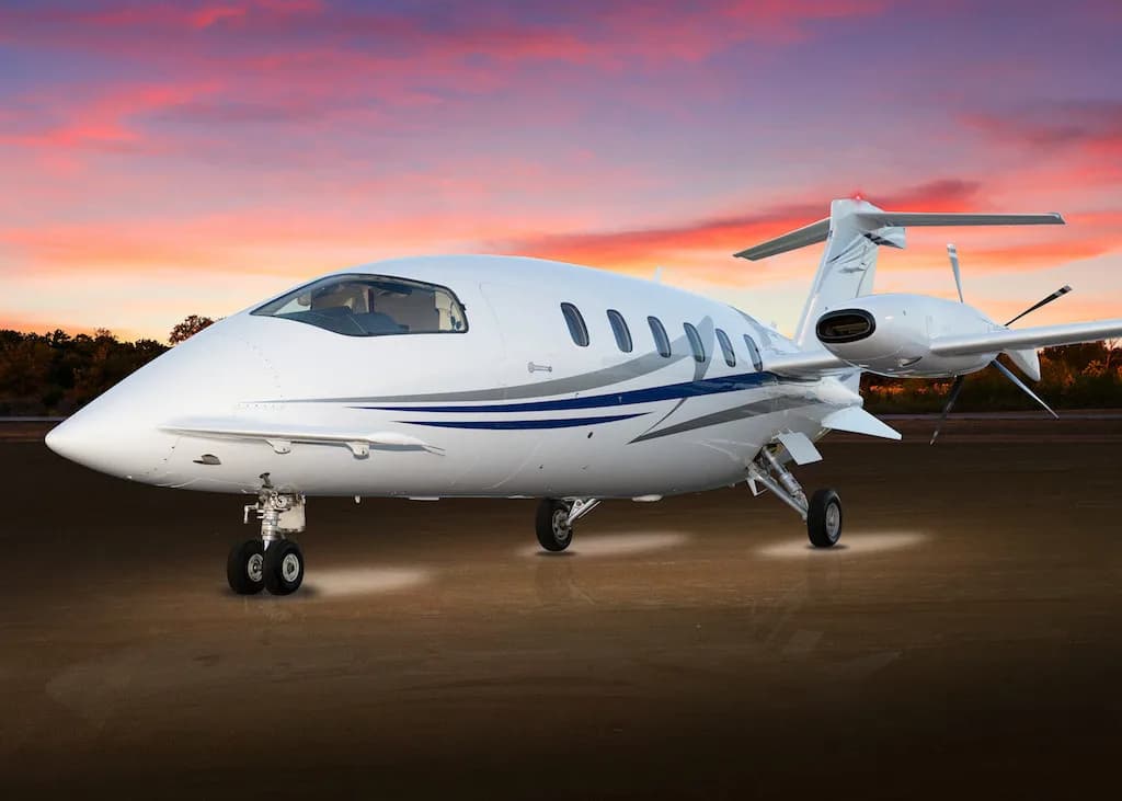 Piaggio Avanti EVO on the tarmac at sunset.