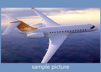 A Bombardier Global Express business jet in flight with a white fuselage and gold tail.