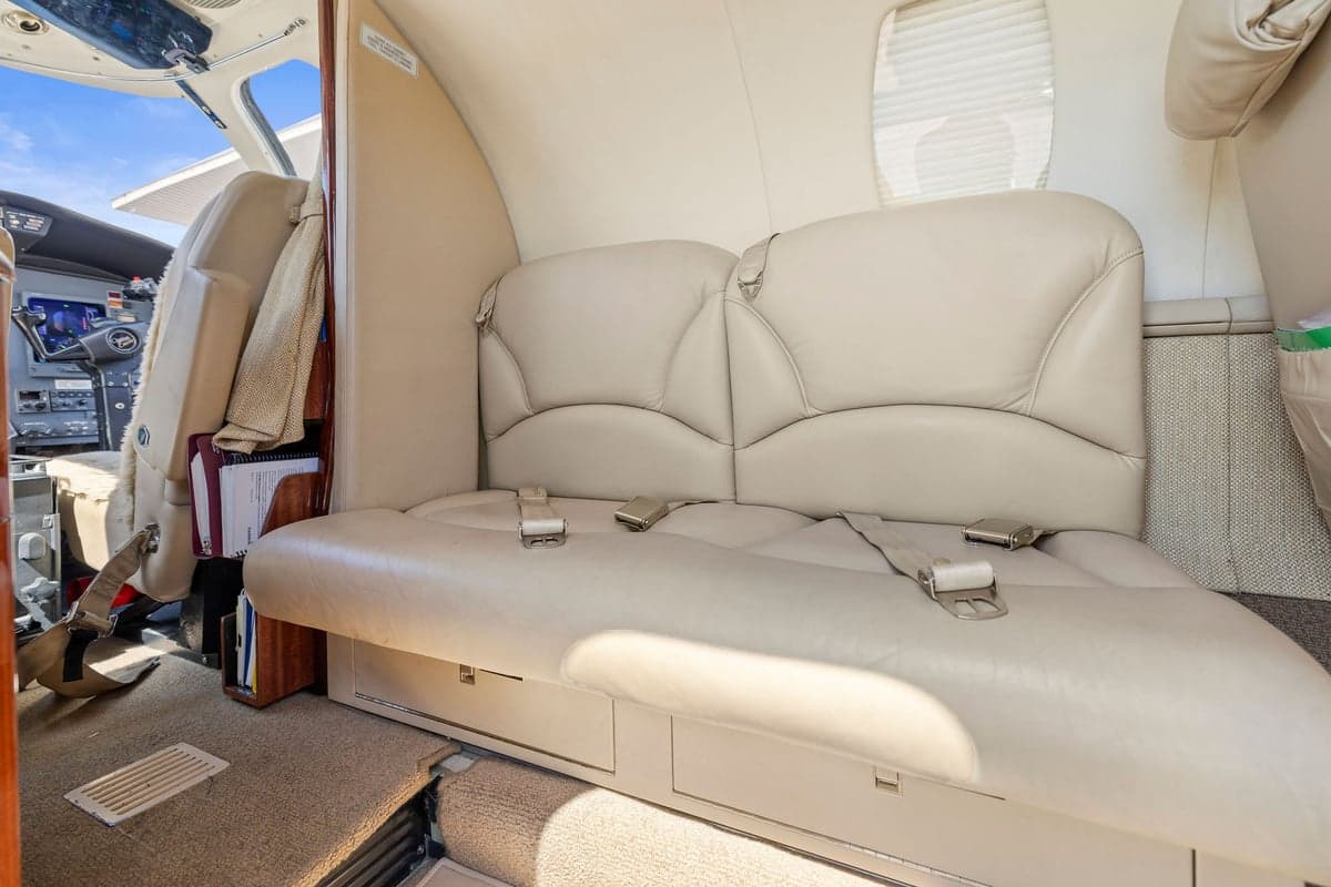 View of the aircraft interior showing a bench seat and cockpit.