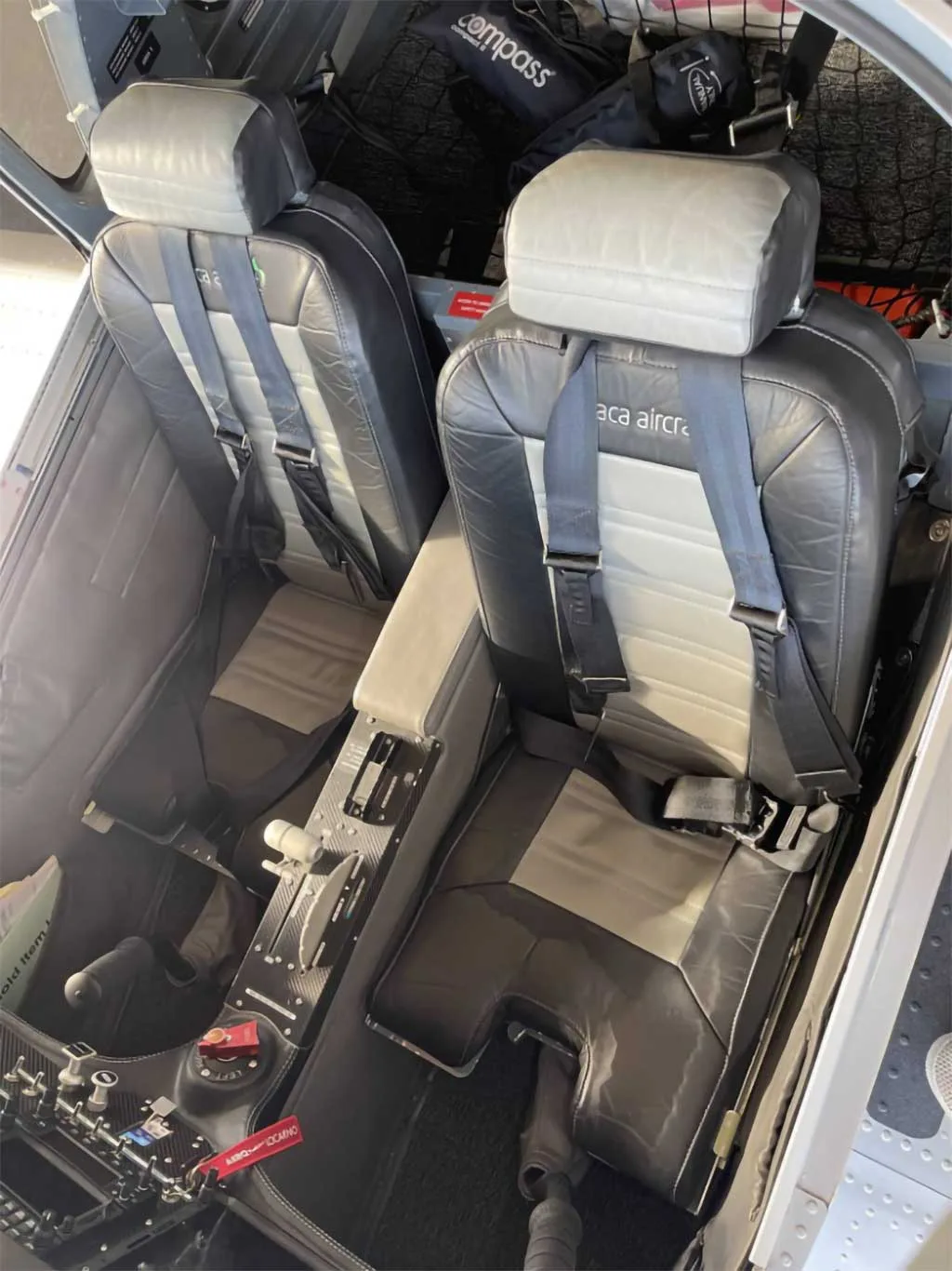 The two-tone grey and black leather seats and center console of a Sonaca 200 aircraft interior.