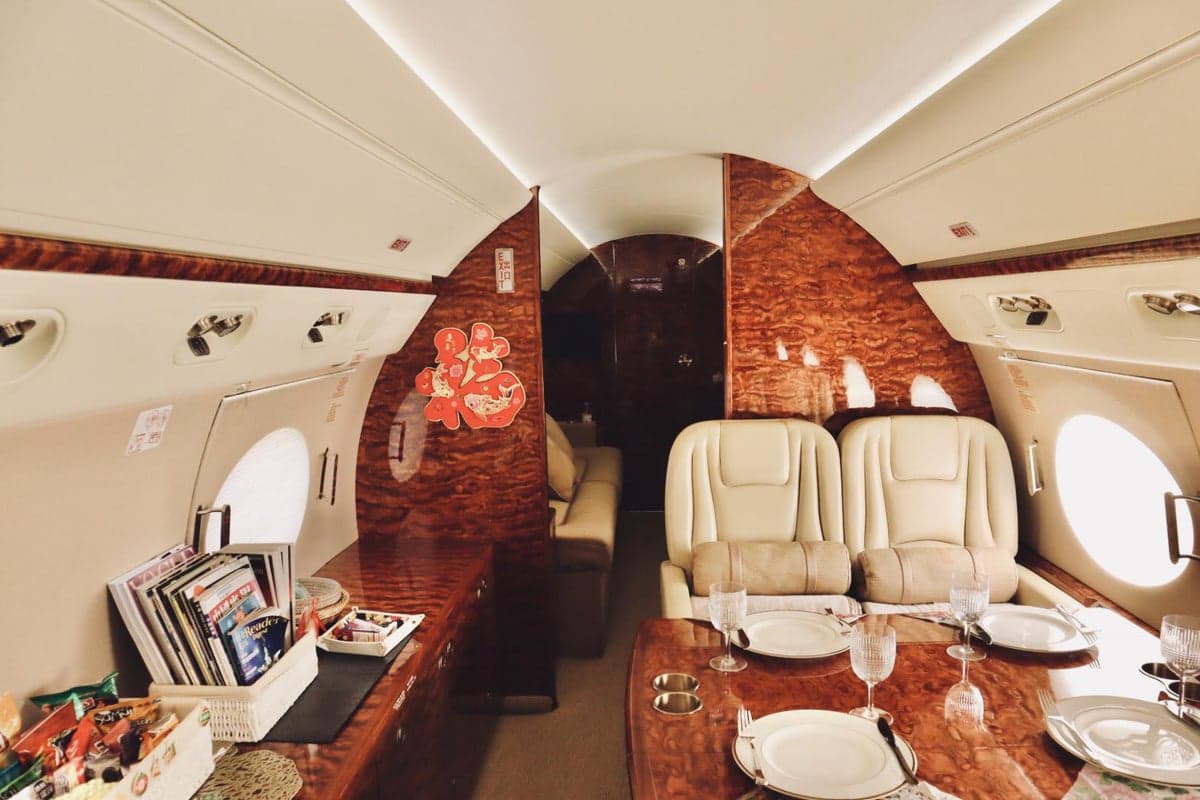 The interior of the aircraft features a dining table and leather seats.