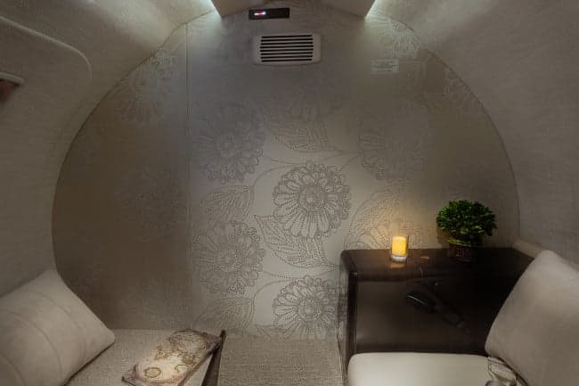 Aft lavatory of the Cessna Citation CJ3+ with floral wallpaper and a small table.