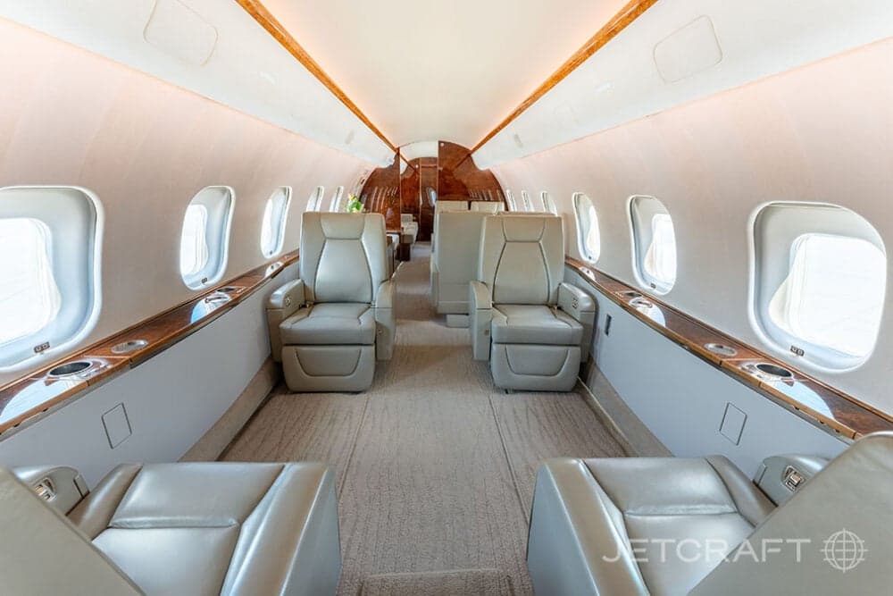 View of the aircraft interior with leather seats and wood trim.