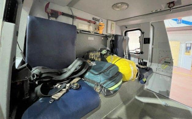 Interior of a helicopter with seats and various equipment.