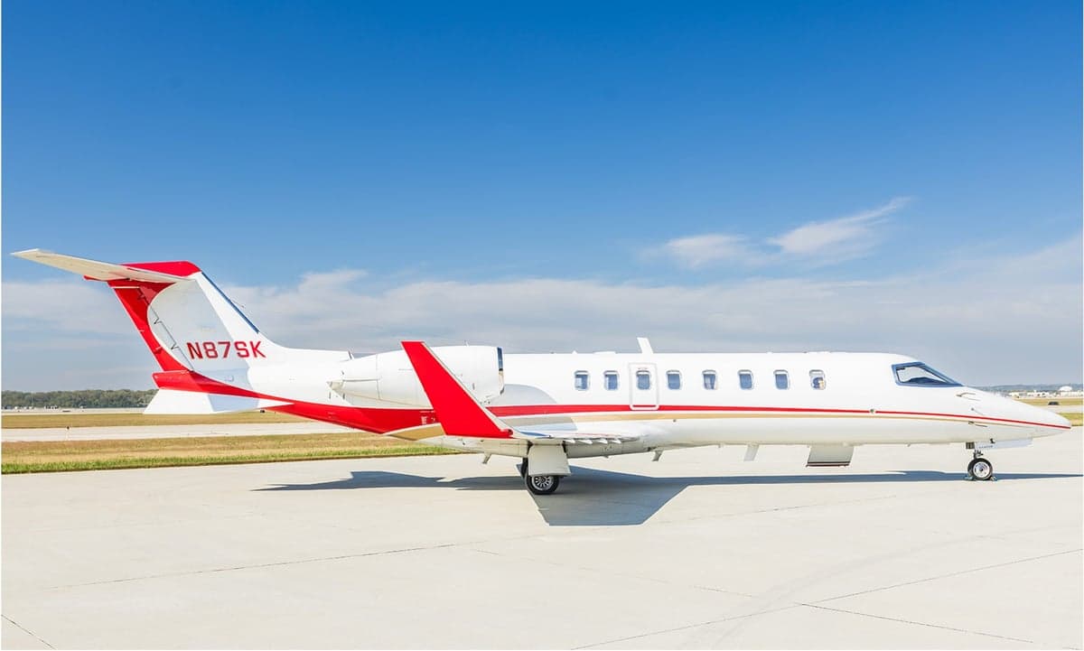 A Learjet 45XR with a white and red paint scheme on the tarmac.