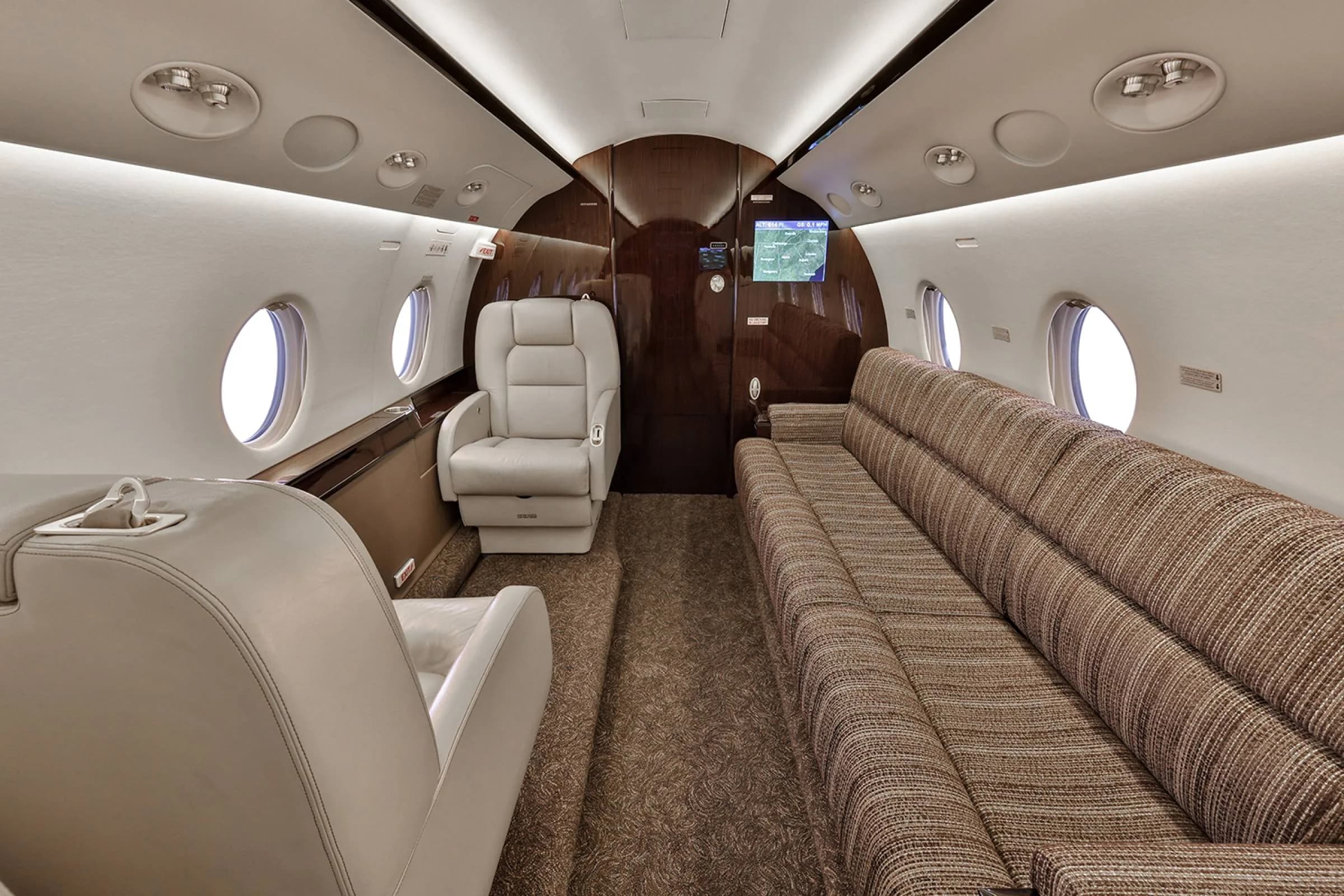View of the aircraft cabin with leather seats and a couch.