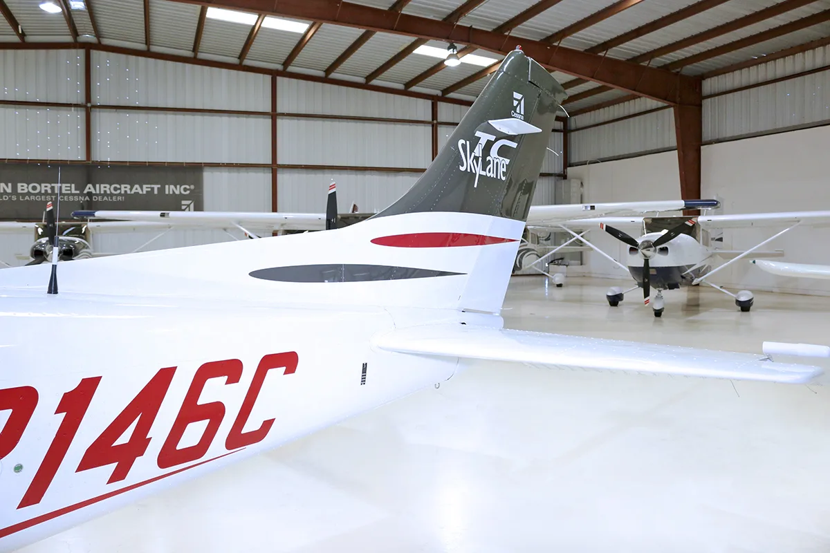A close-up of the tail section of a white Cessna 182 Skylane with registration N2146C, showing the "Skylane" logo.