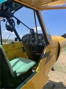 View of the cockpit of a yellow Cubcrafters aircraft.