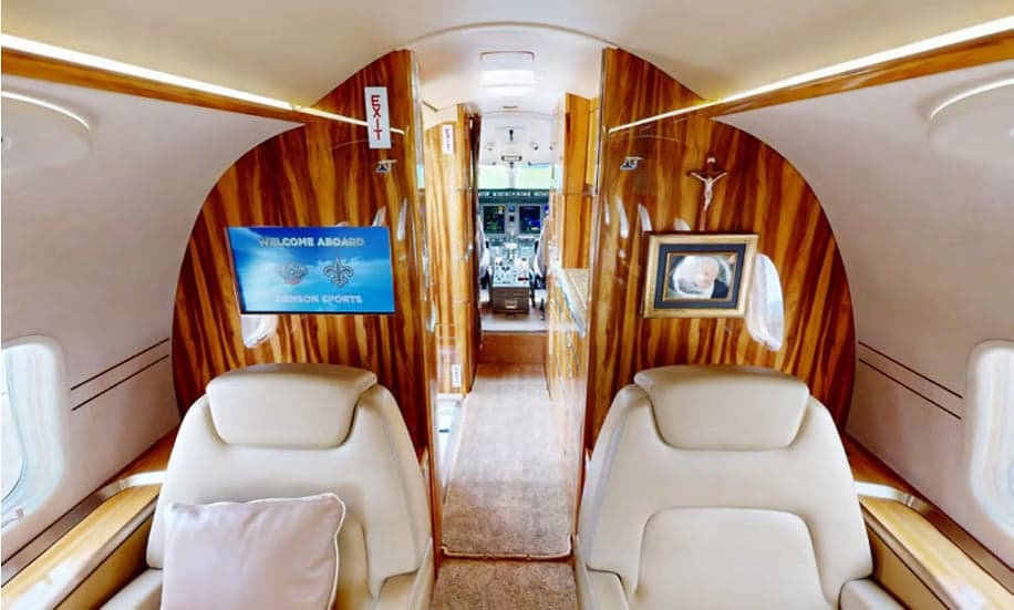 The interior of the Challenger aircraft features wood paneling and leather seats.