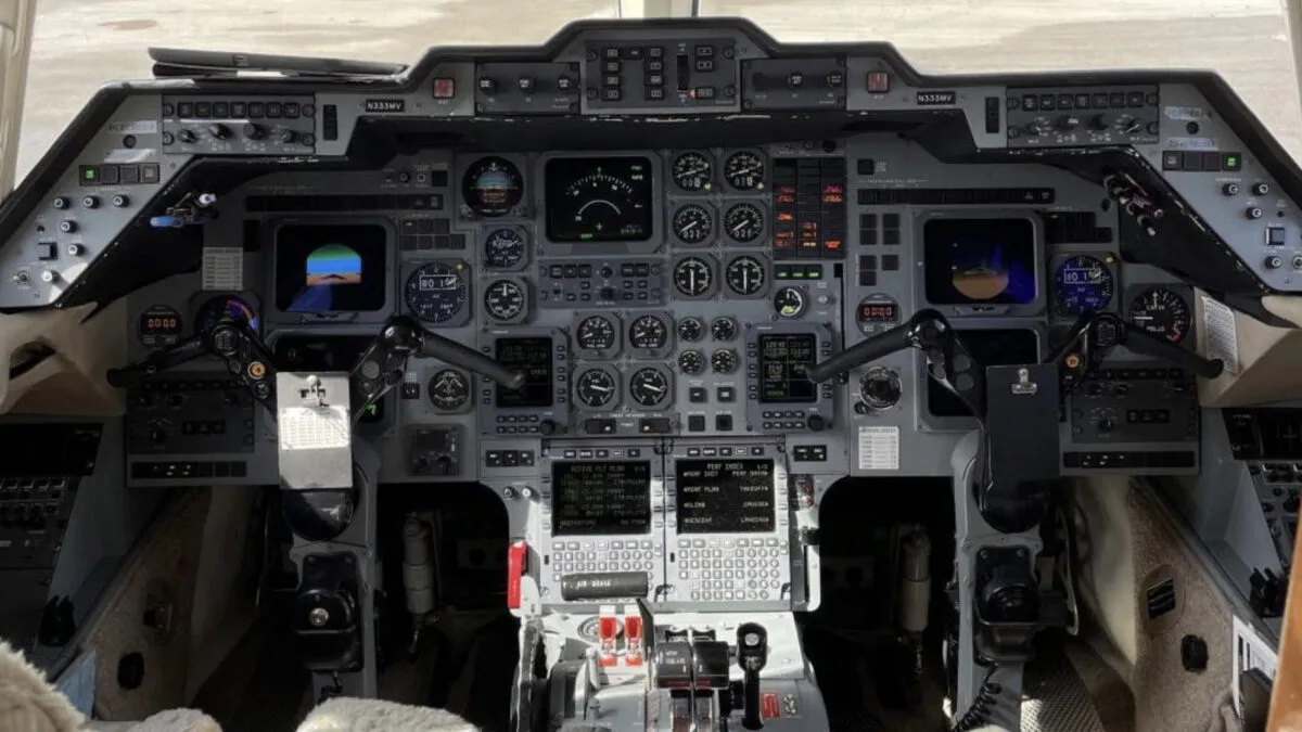 The cockpit of a business jet, showing a complex array of analog and digital instruments and controls.