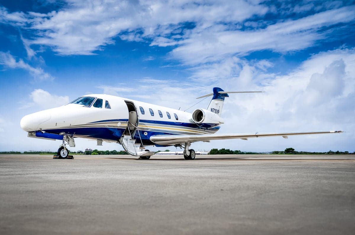 A Cessna Citation CJ3+ sits on the tarmac with its door open.