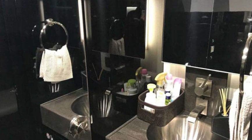 A view of the aircraft lavatory with a sink and mirror.