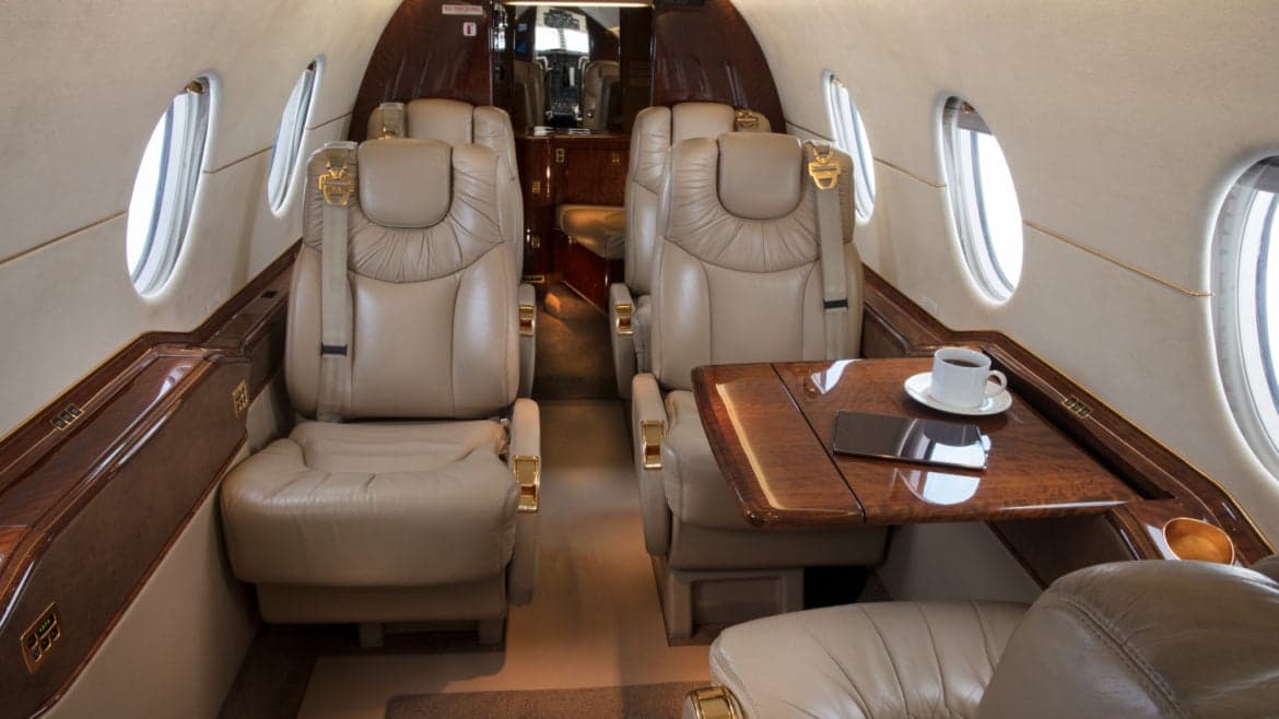 View of the aircraft's interior, showing the seating arrangement and table with a cup of coffee.