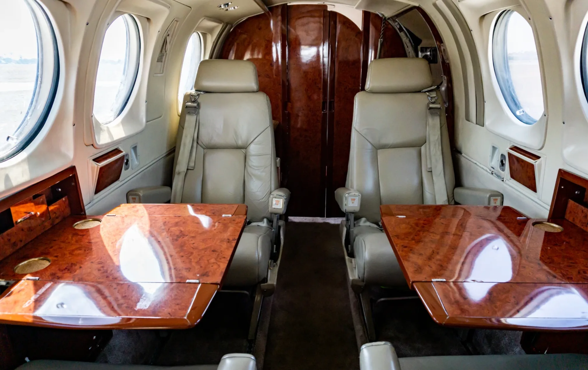Interior view of the Beechcraft King Air 200 cabin with two seats and fold-out tables.