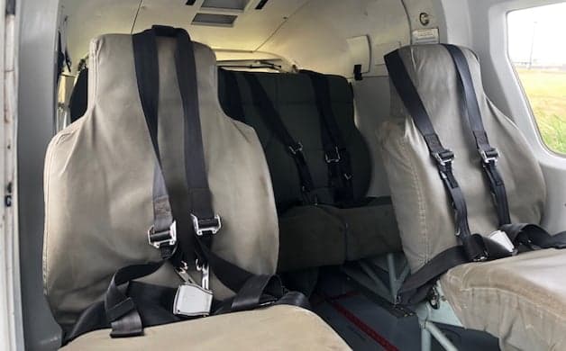 View of the helicopter cockpit from the side, showing the instrument panel and seats.