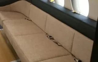 Interior view of the aircraft cabin with a beige couch.