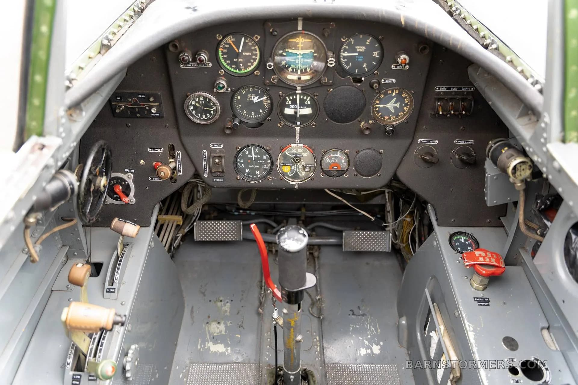 An overhead view of the Nanchang CJ-6 cockpit, showing the instrument panel and controls.