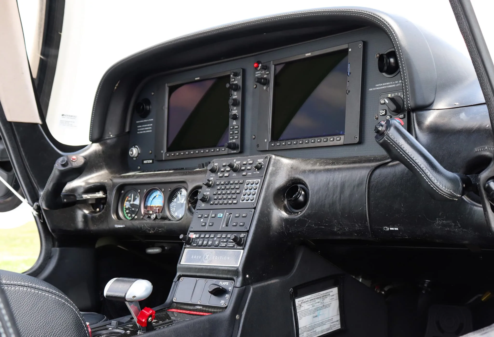 An angled view of the Cirrus SR20 cockpit showing the instrument panel and controls.
