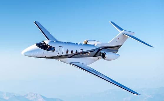 A Learjet 75 Liberty in flight against a blue sky.