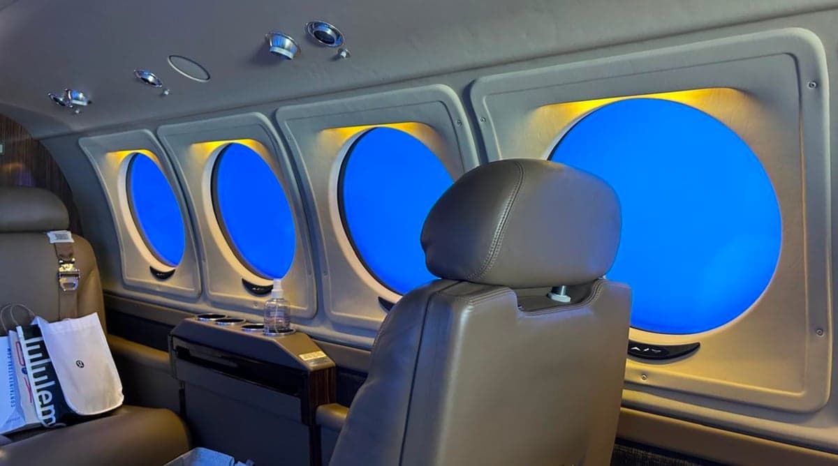 Interior of a King Air 250 with leather seats and round windows.