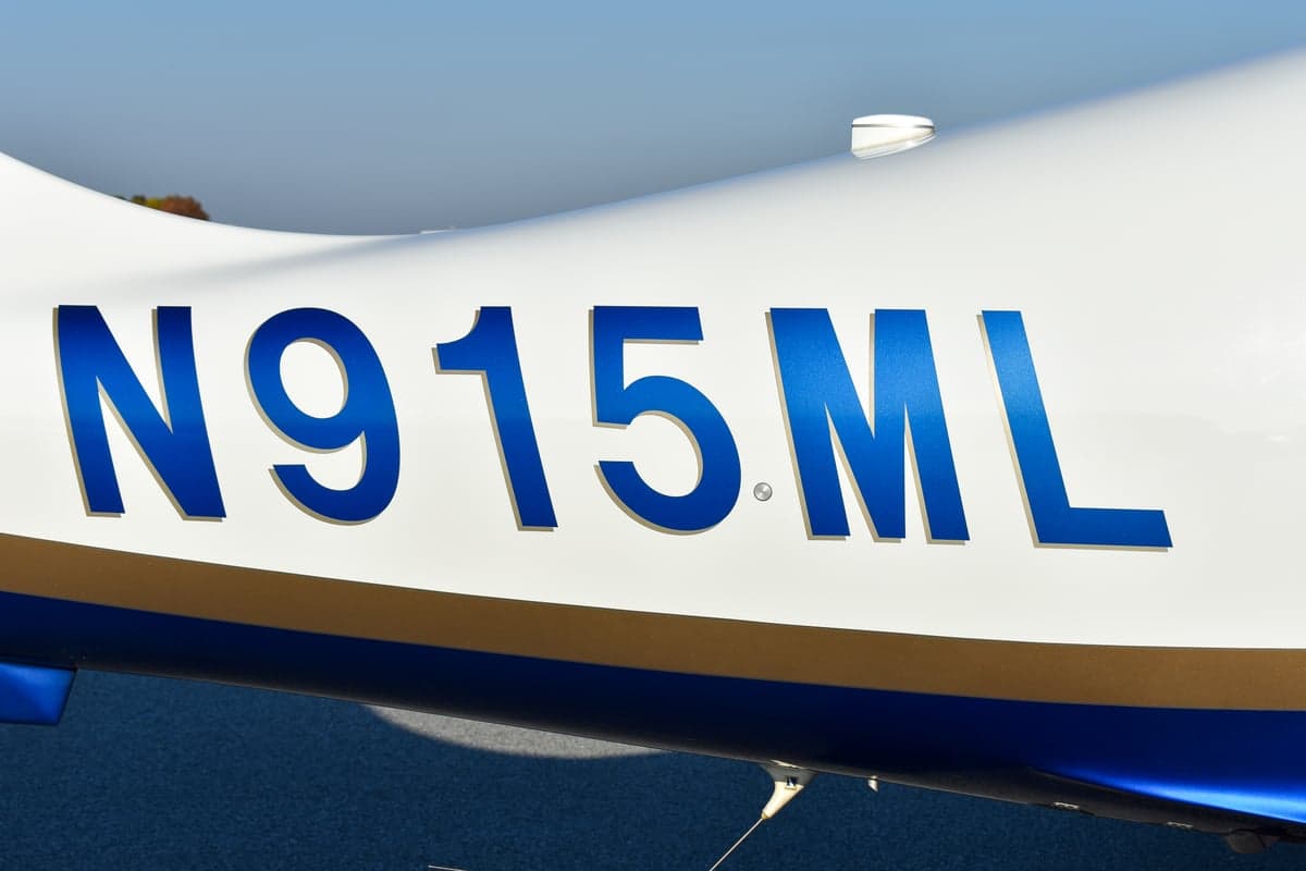 Rear view of the white and blue Cessna aircraft N915ML on the tarmac.