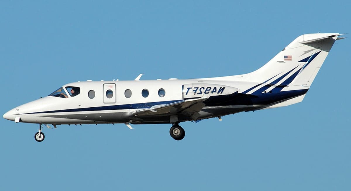 Hawker jet with blue and white paint scheme in flight.