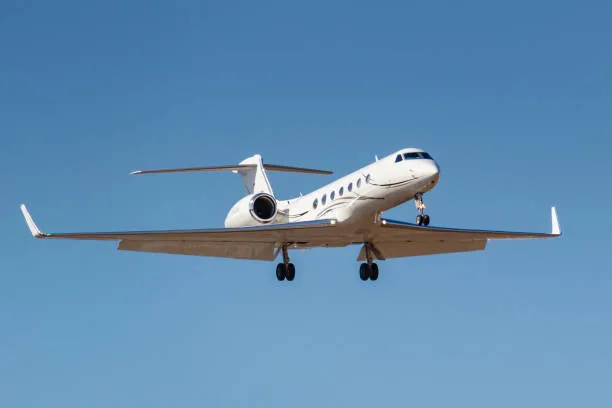 A white Gulfstream jet on approach to landing.