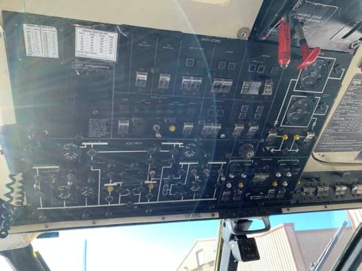 An overhead panel in an aircraft cockpit, filled with various switches, dials, and indicators.