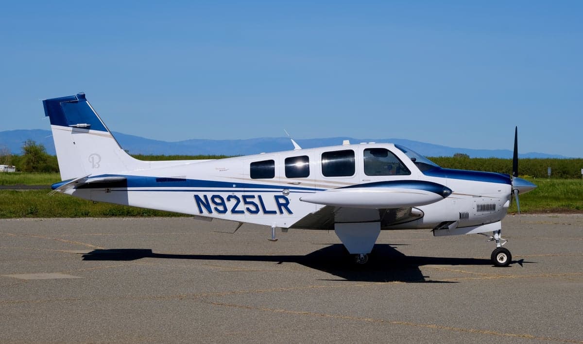 Beechcraft Bonanza N925LR on a ramp with white and blue paint scheme.