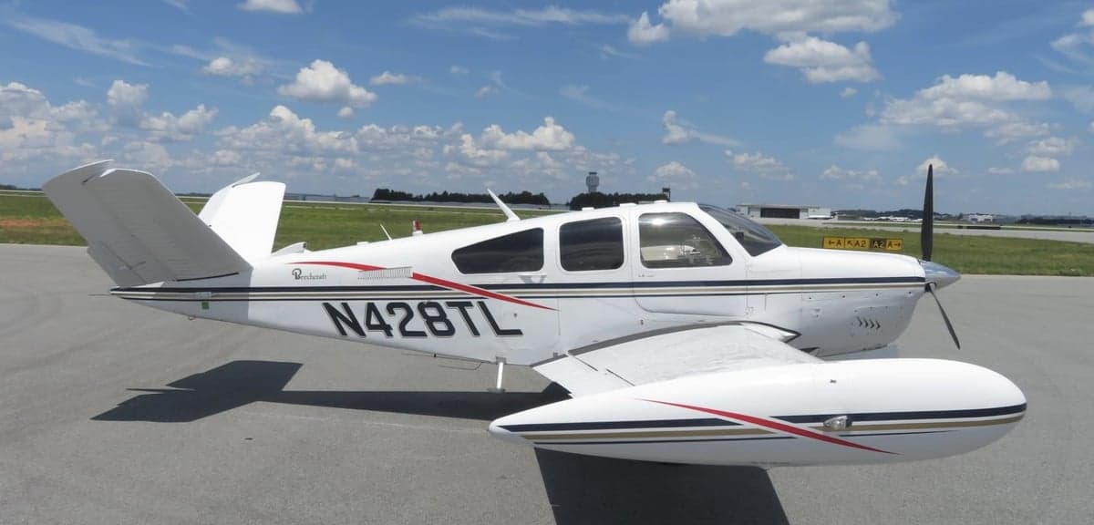 Side view of a Beechcraft Bonanza aircraft with registration N428TL on the tarmac.