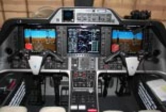 The cockpit of an aircraft is shown with multiple display screens.
