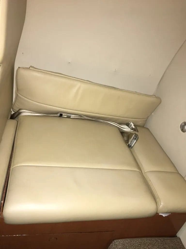 Close-up of a tan leather seat with a seatbelt.