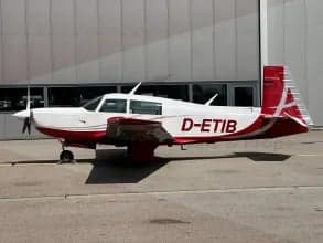 Side view of the D-ETIB aircraft with a red and white paint scheme parked on the tarmac.