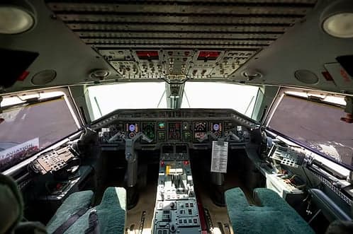 The spacious cockpit of a private jet, featuring a modern instrument panel and dual yokes.