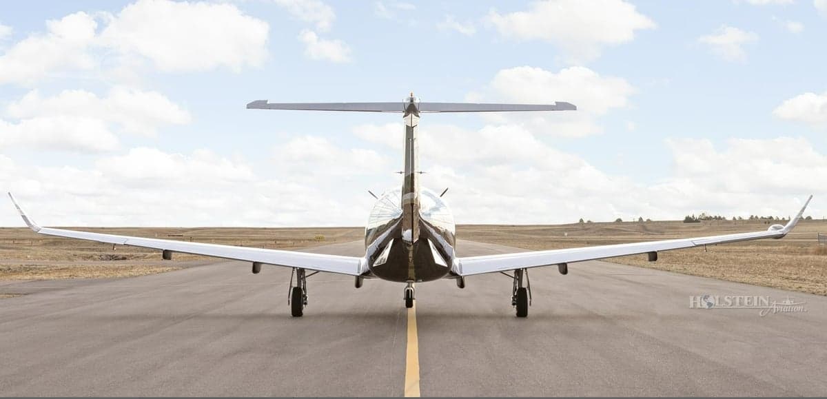Rear view of Pilatus PC-12 aircraft on the runway.