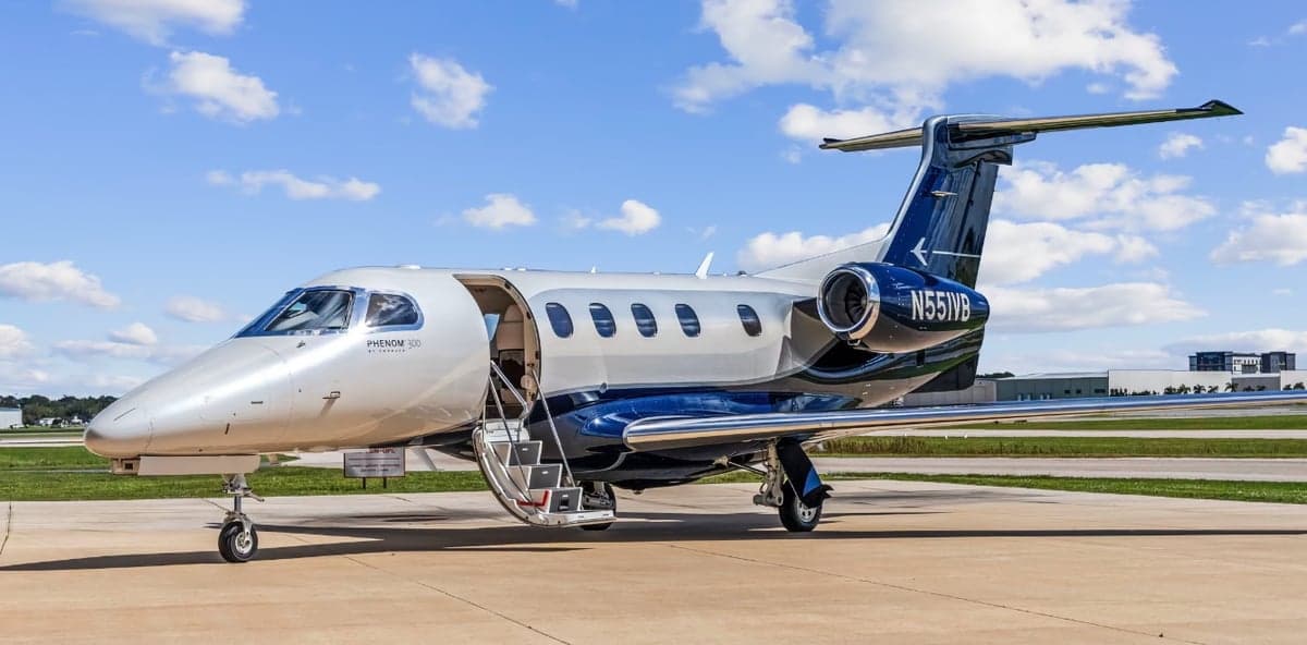 A Phenom 300 aircraft with registration N551VB with the door open.