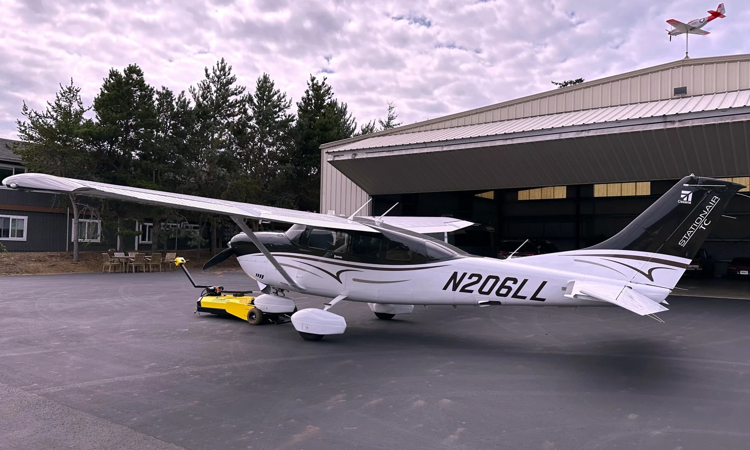 Cessna 206 Stationair aircraft N206LL parked outside a hangar.
