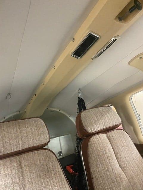 View of the aircraft's interior, showing the seats and overhead panel.