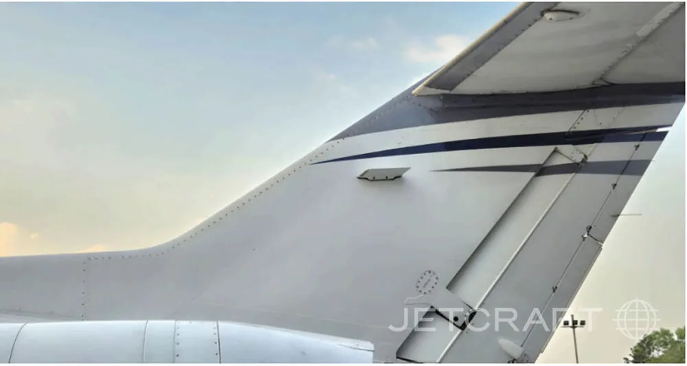 A close-up view of the white and blue tail section of a business jet.