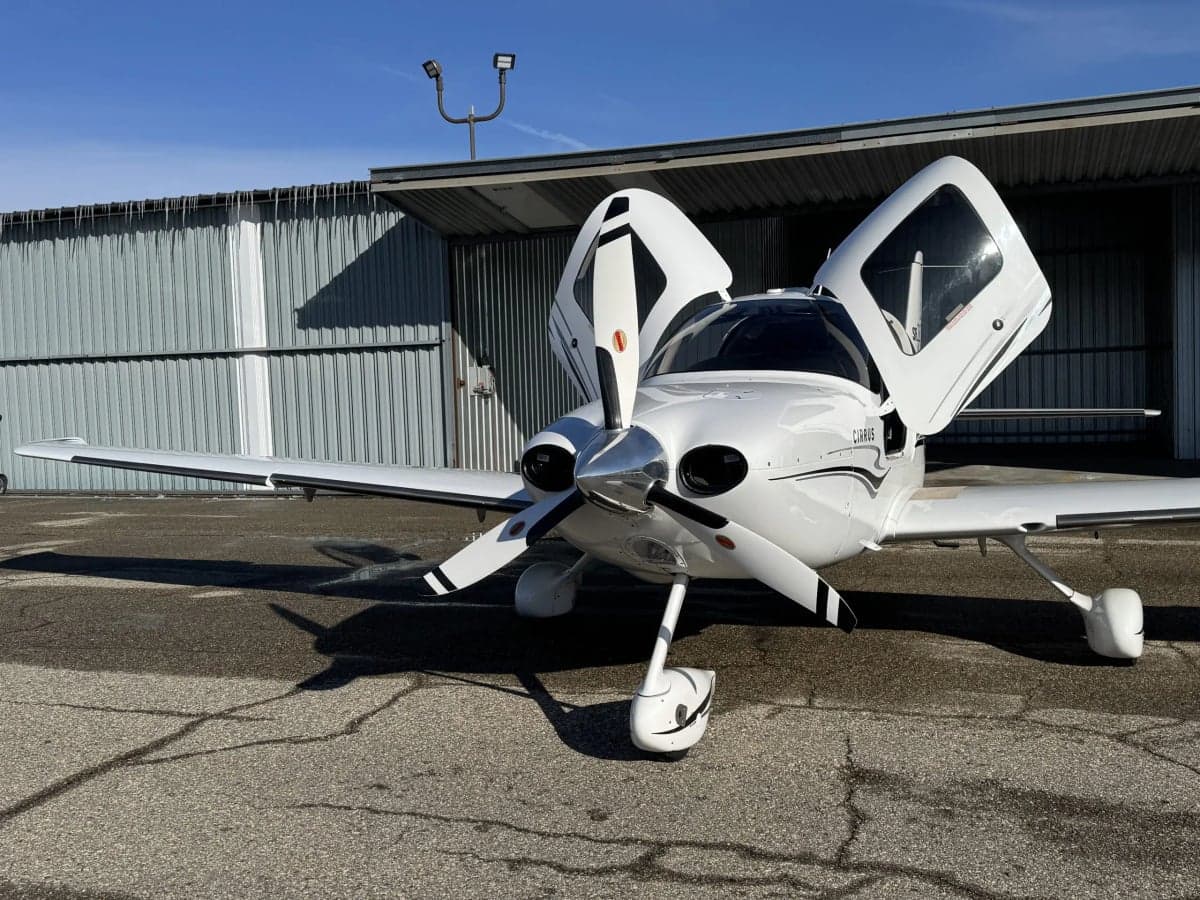 Front view of a Cirrus SR22T with open doors, parked on the tarmac.