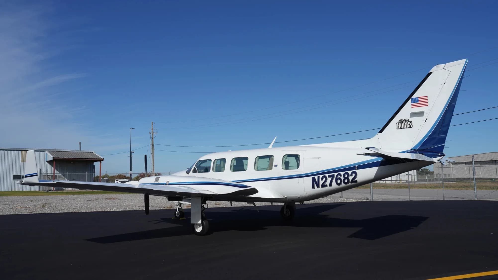 Side view of the white and blue twin-engine aircraft with tail number N27682.