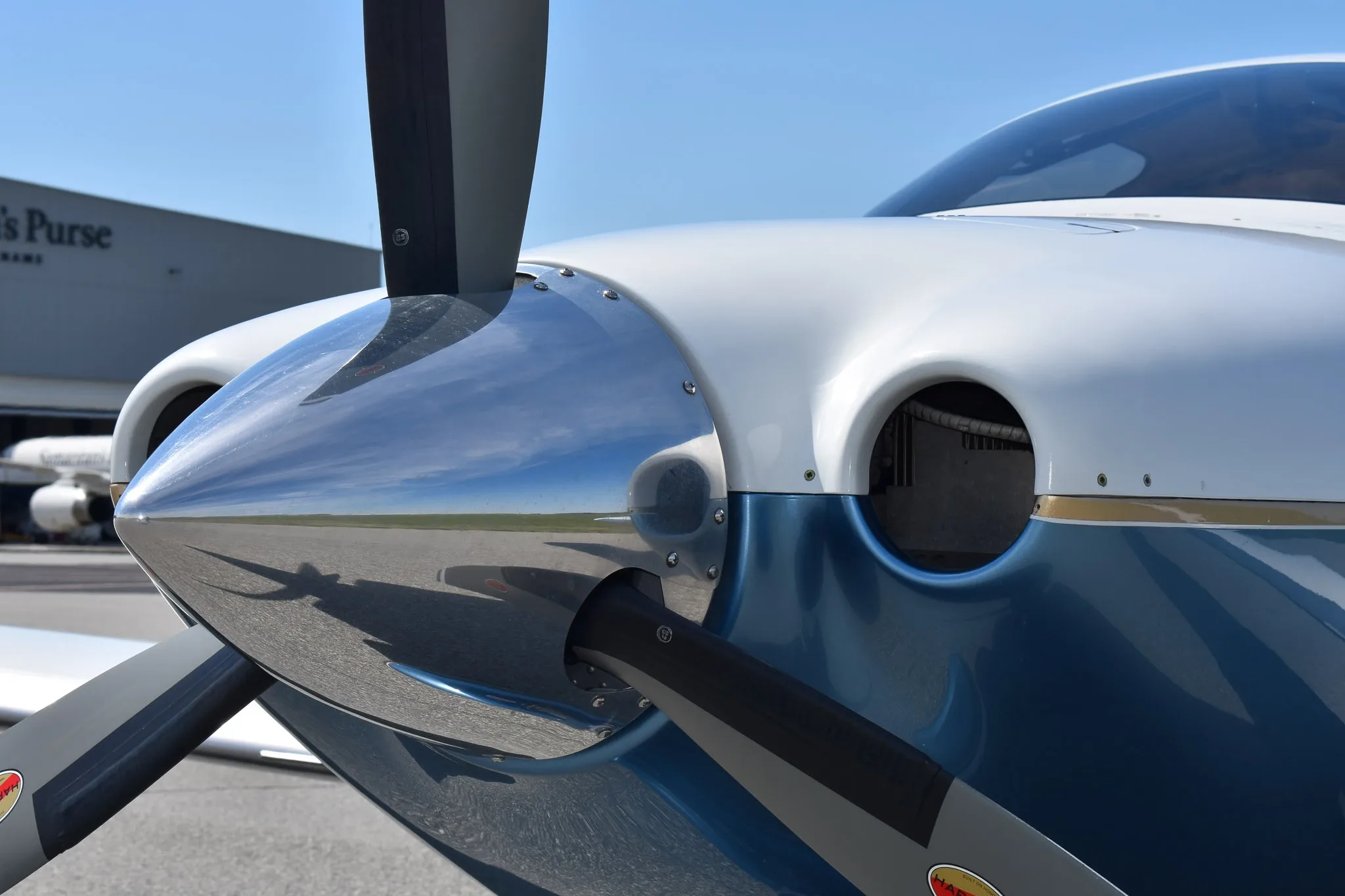 Close-up view of the polished propeller spinner and engine cowling of the aircraft.