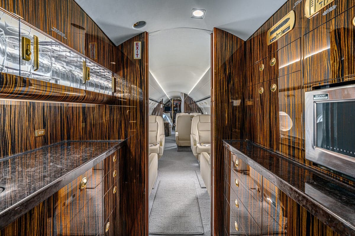 The interior of the aircraft features wood grain finishings and cream-colored leather seats.