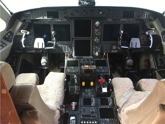 The cockpit of the aircraft features multiple display screens and controls.