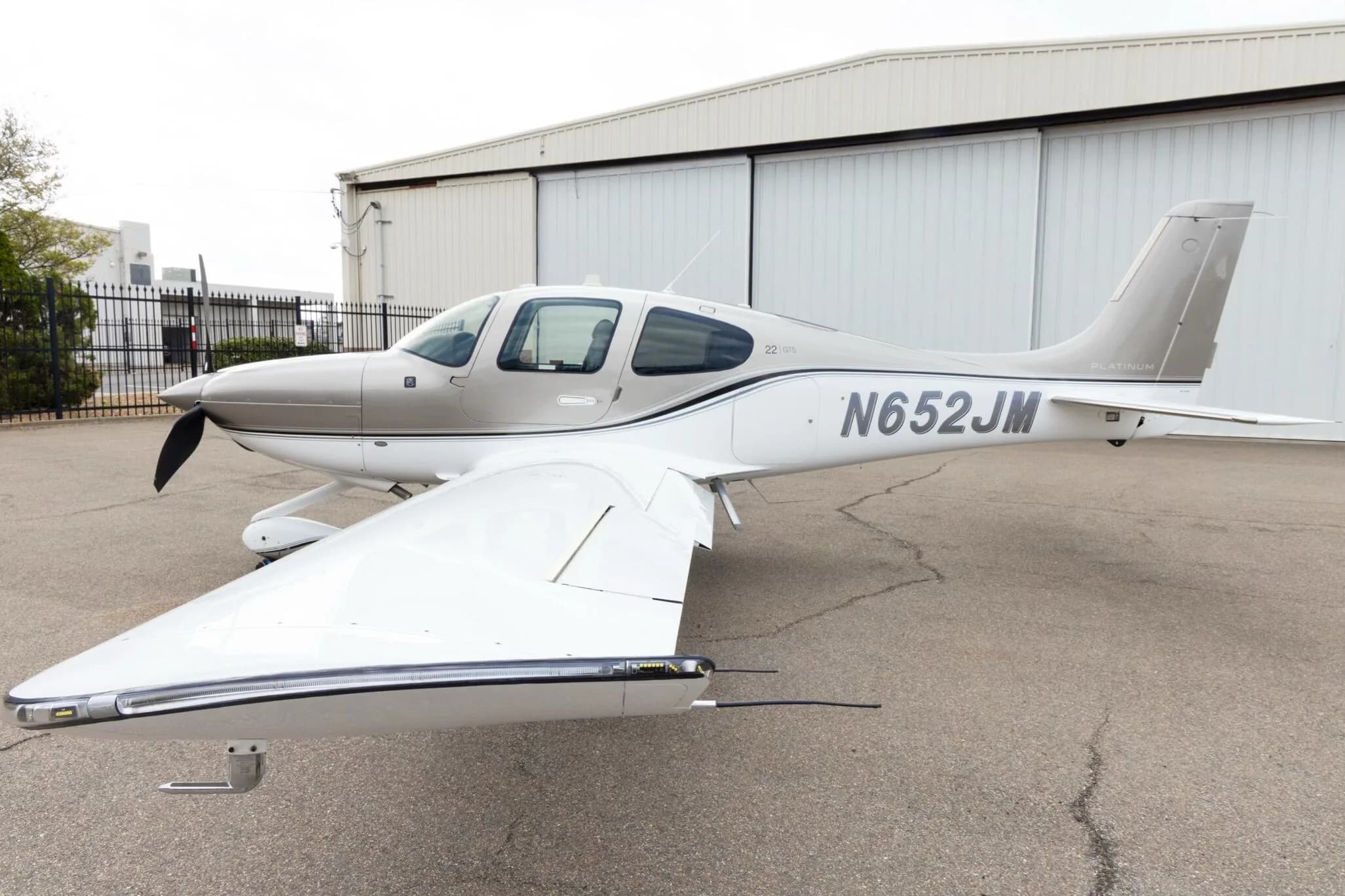 A close-up side view of the silver and white Cirrus SR22 aircraft with N652JM registration, showing "PLATINUM" and "22 GTS" markings.