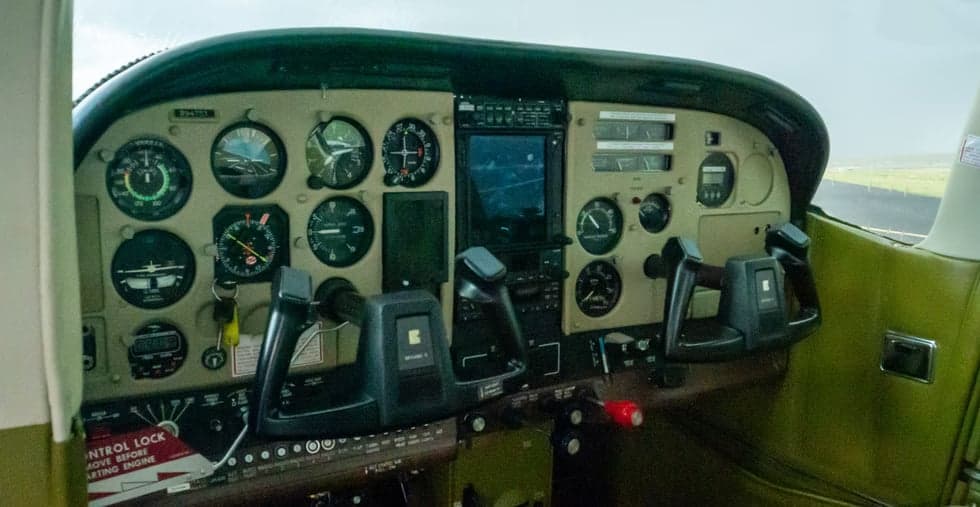 The instrument panel and controls of an aircraft cockpit.
