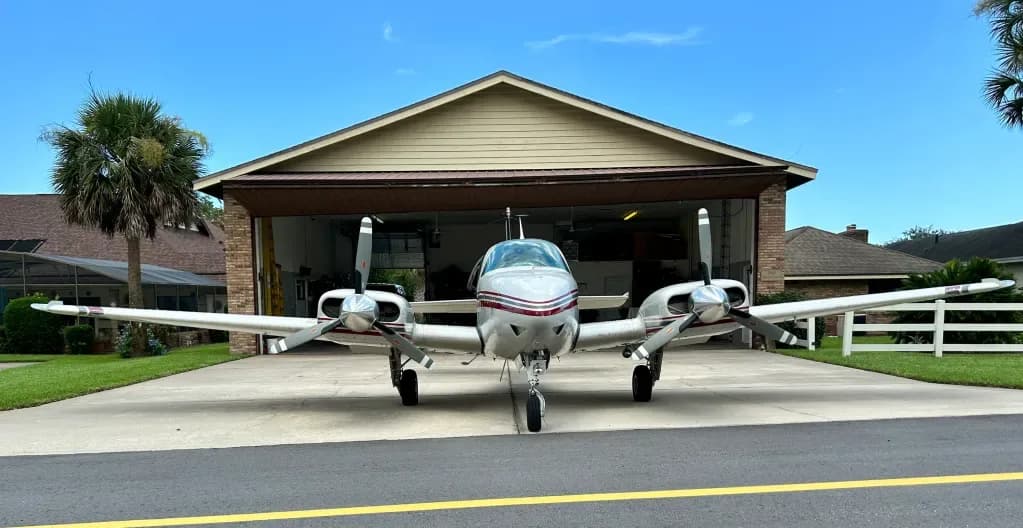 Front view of the Beechcraft Baron N41TG parked in front of a hangar.