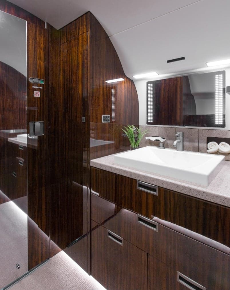 A view of the aircraft's lavatory with a sink and mirror.