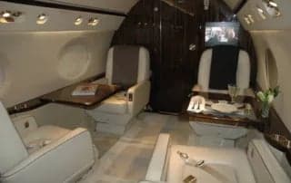 A view of the aircraft interior with seating and tables.